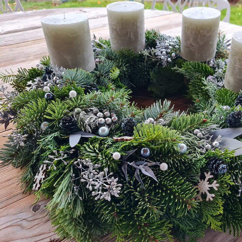 Elegante Winterdeko: Kranz in Silber-Grün mit natürlichem Look mit vier Kerzen zum Advent.