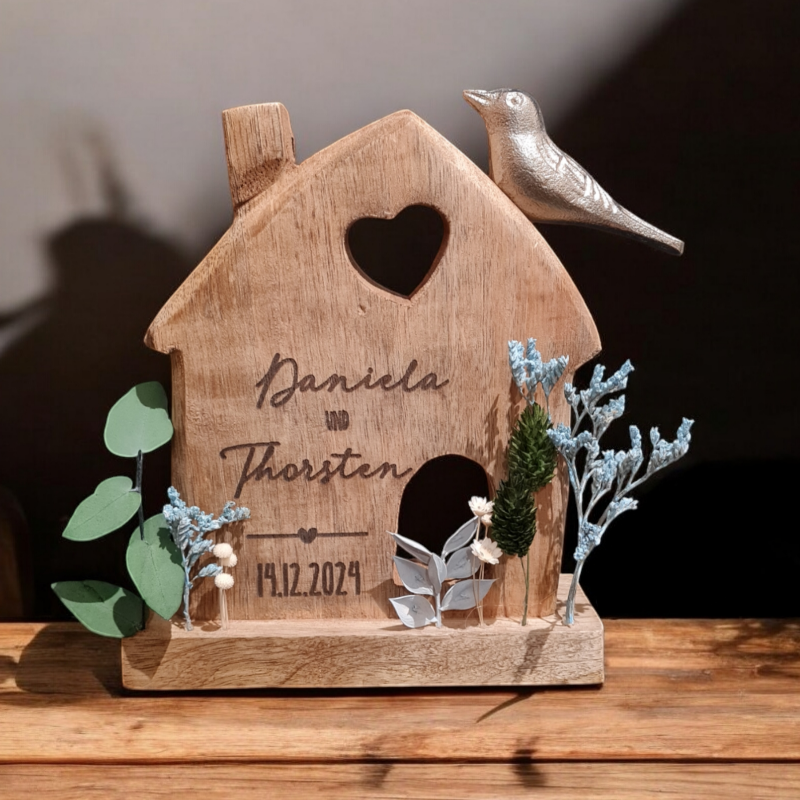 Ein haus aus Holz mit Wunschtext graviert. es wird für ein junges Paar beschriftet und eignet sich als Geschenk zu Hochzeit, Valentinstag, Jahrestag, Einzug, gemeinsame Wohnung oder Haus.