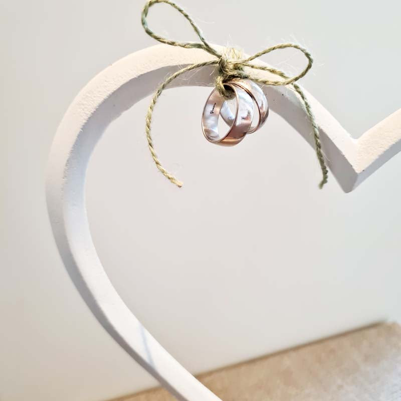 Die Ringe werden an ein weißes Herz gebunden zur Trauzeremonie gebracht. Eine schöne Alternative zu Ringkissen, Ringdose, Ringbox oder Schatulle ist das hochwertige und liebevoll gestaltete Herz aus Alu