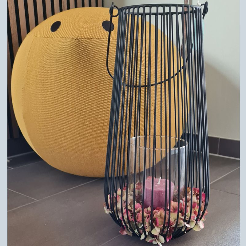 Laterne aus schwarzen Metallstäben mit Glaswindlicht und Stumpenkerze. Dekoriert mit Kranz aus getrockneten Hortensien in herbstlichen Rottönen. Dekorationsidee für Outdoor, Eingangsbereich, Balkon, Terrasse.