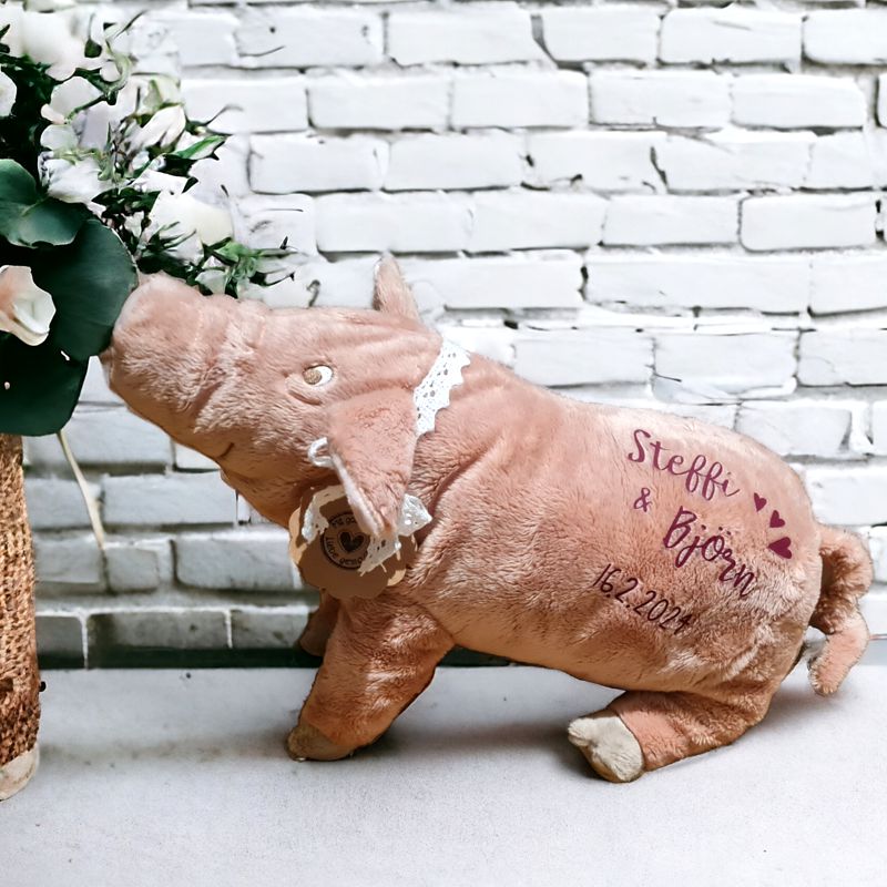 Ein Kuscheltier Schweinchen wird mit Text im Handlettering Stil personalisiert. Von ganzem Herzen Glück wünschen wir mit diesem bezaubernden und kuschelweichen Geschenk. Ein entzückendes Schwein zur Hochzeit, zur Geburt, zu Prüfungen oder zu allen weiteren Gelegenheiten in denen etwas Glück gut tut.