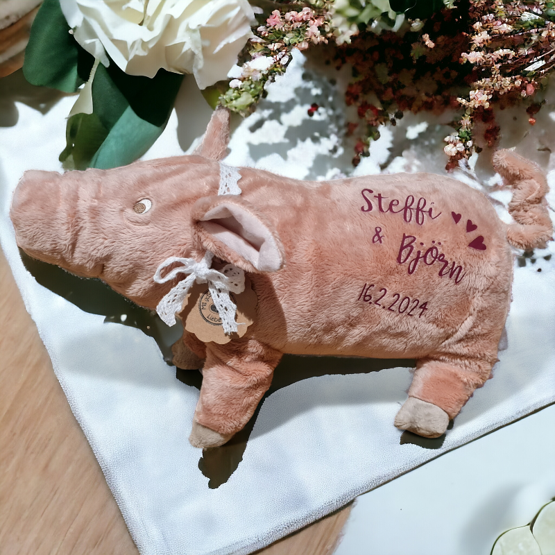 Ein Kuscheltier Schweinchen wird mit Text im Handlettering Stil personalisiert. Von ganzem Herzen Glück wünschen wir mit diesem bezaubernden und kuschelweichen Geschenk. Ein entzückendes Schwein zur Hochzeit, zur Geburt, zu Prüfungen oder zu allen weiteren Gelegenheiten in denen etwas Glück gut tut.