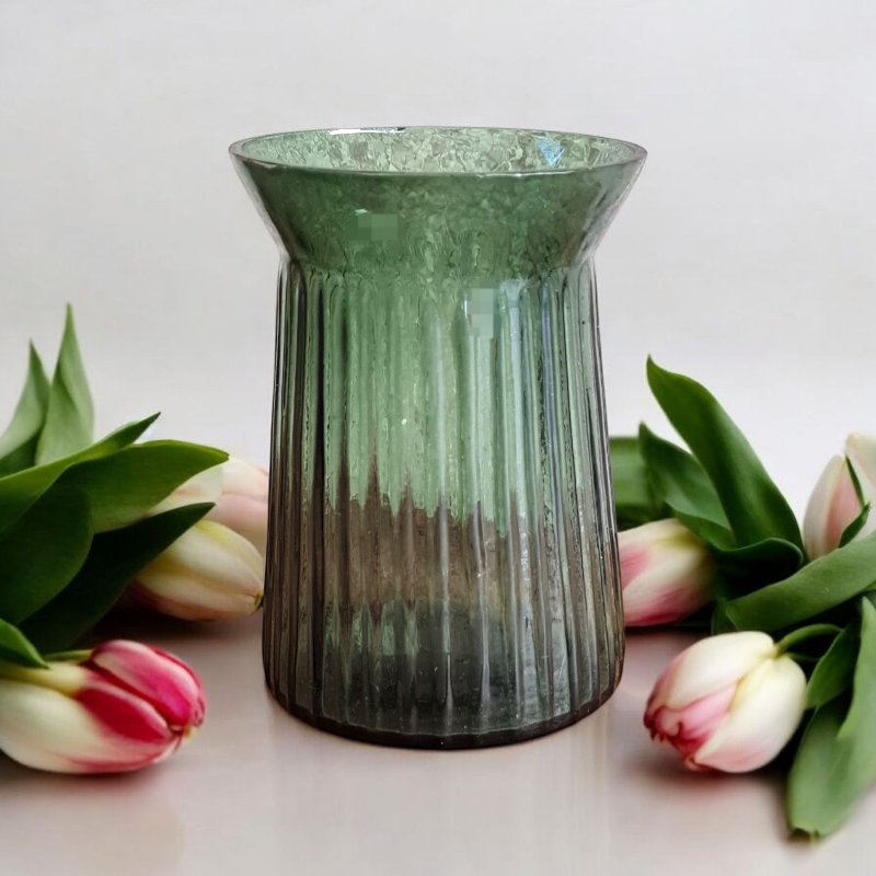 Eine kleine grüne Glasvase in der perfekten Größe für stimmige Tischdekortionen zu Taufe, Hochzeit, Kommunion oder Konfirmation. Aus transparent gefärbten Glas mit modernen Rillen in der neuen Trendfarbe Farn. Sie schimmert waldgrün und passt perfekt zu kindgerechten Waldtier und Feen Motiven