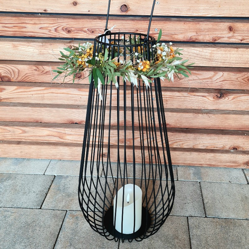 Herbstdekoration modern, große Laterne aus Metall schwarz. Das moderne Windlicht mit Glaseinsatz wird mit einem Kranz aus frischem Grün und Trockenblumen geschmückt. Eine hochwertige Dekoration für Dein Zuhause.