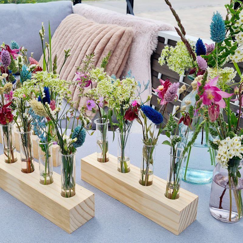 Detailbild einer Tischdekoration mit zarten Wildblumen und bunten Gräsern. Sehr moderne Tischdeko zur Party.