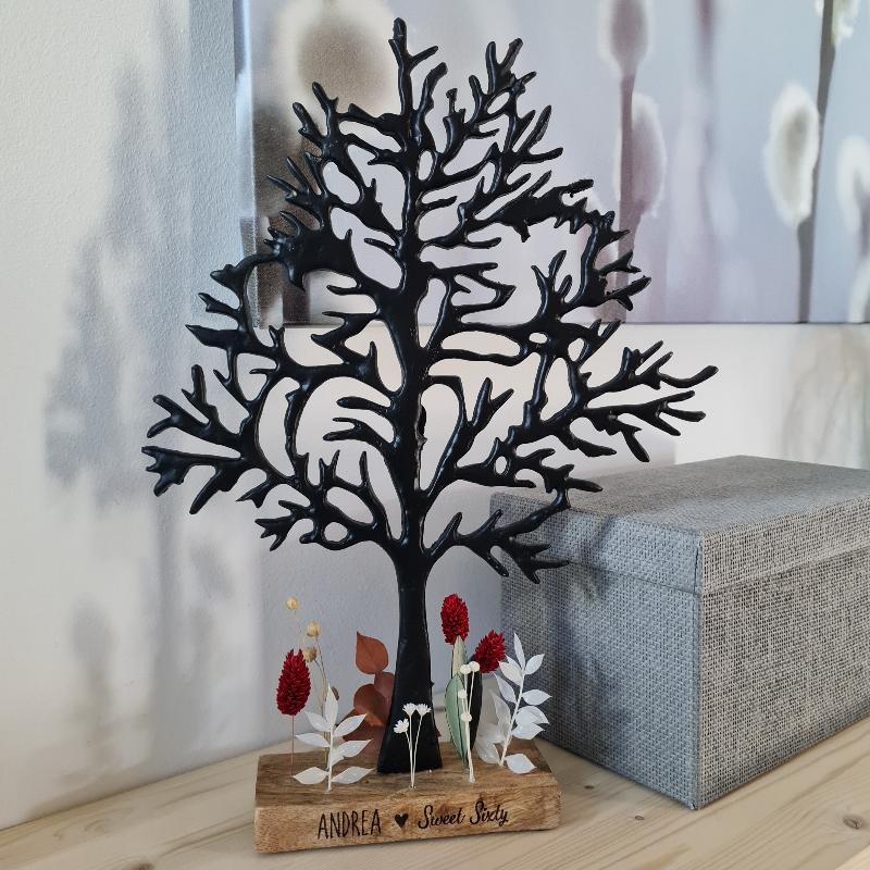 Ein großer Baum aus Metall zum Geburtstagsgeschenk vorbereitet. Der Sockel ist nach Wunsch persönlich beschriftet und Trockenblumen in Farben nach Wahl bilden eine Basis für dieses exklusive und hochwertige Geschenk zum runden Geburtstag. 