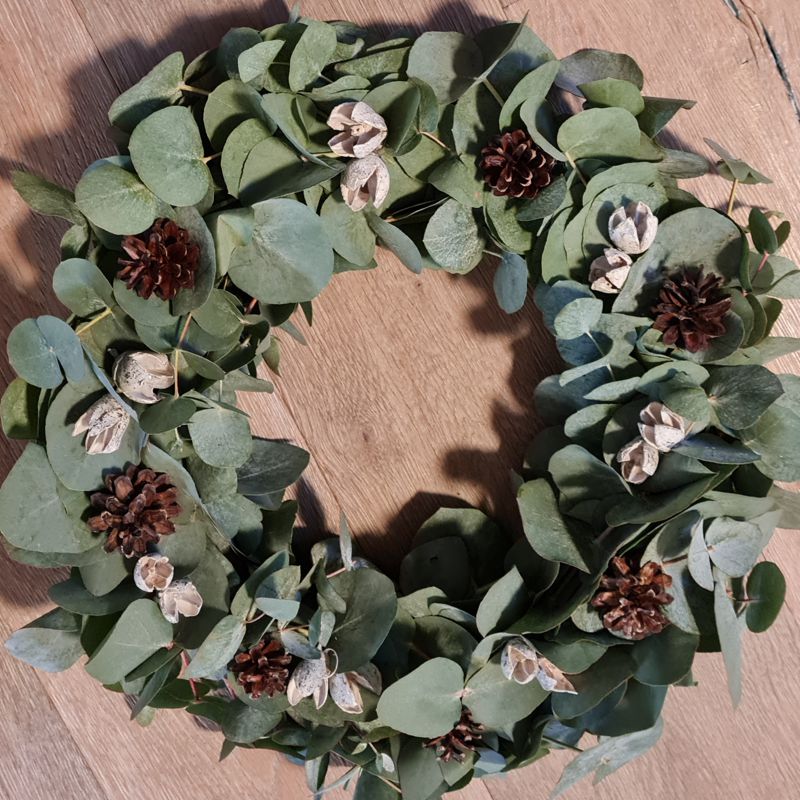 Detailansicht für Winterdekoration im Betonring, Eukalyptusranken mit kleinen Tannenzapfen.