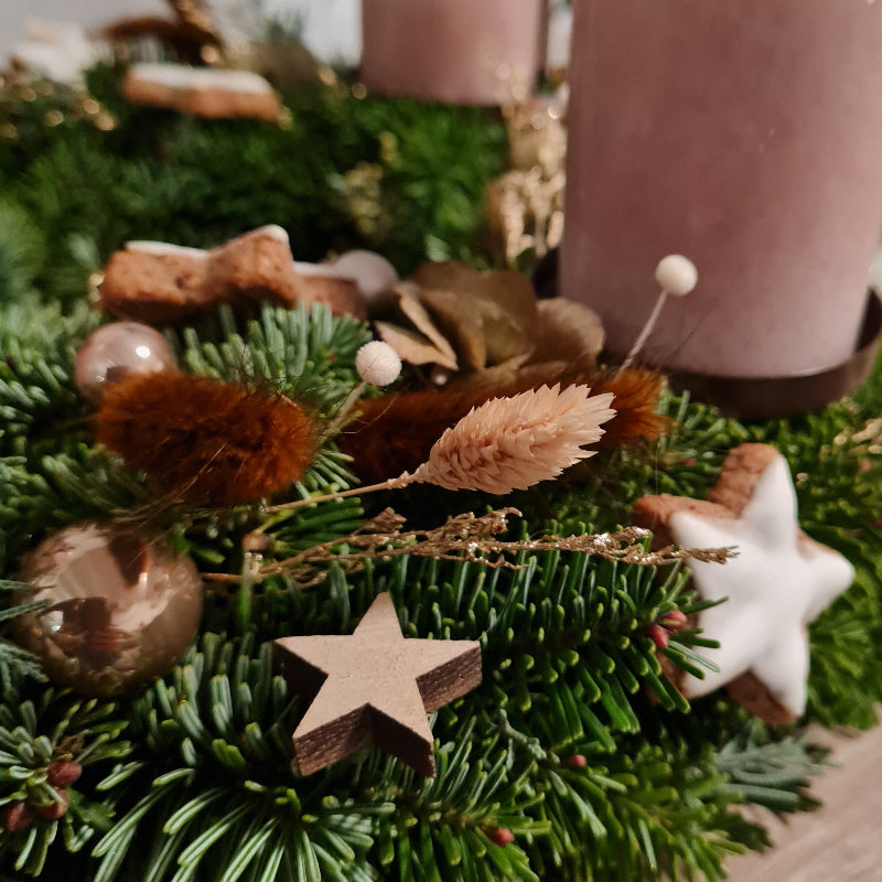 Der Kranz Zimtstern in Detailansicht. Die hochwertigen Materialien kombinieren warme Brauntöne, Trockenblätter und feine Goldakzente.
Er verströmt Behaglichkeit und macht jeden Raum zu einem Ort des Wohlgefühls.