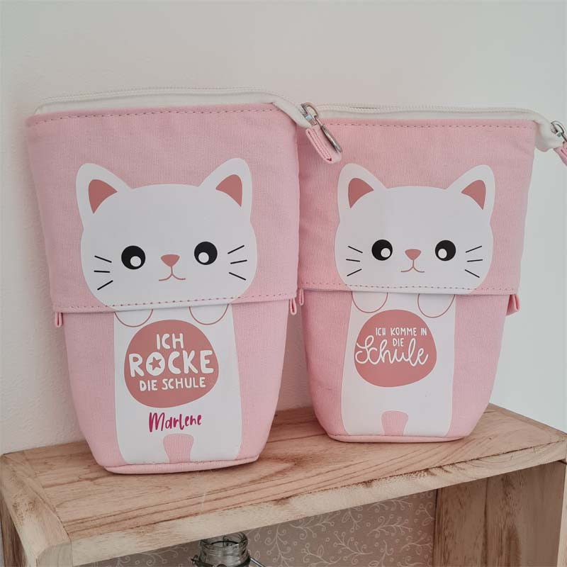 Eine Federtasche mit Katzenmotiv in rosa. Das Mäppchen kann zum Stiftehalter ausgezogen werden und dient als Schlampermäppchen. Wunschtext und Namen sind möglich. Ein süßes Geschenk für Mädchen zur Einschulung.