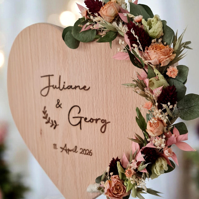 Detailansicht auf Herz aus Buchenholz mit Wunschtext graviert. Geschenk für Hochzeit, Ehejubiläum. Trockenblumenranke mit Rosen und Eukalypzus.