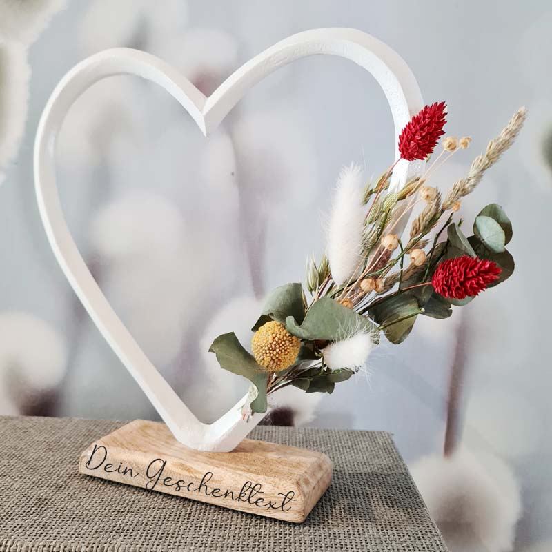 Weißes Herz aus Alu auf Sockel aus Massivholz. Der Sockel ist nach Wunsch gelasert und kann Wunschtext oder Namen und Datum tragen. Trockenblumen schmücken das Geschenk zur Hochzeit oder zum Jubiläum