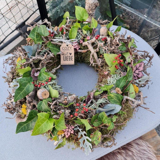 Mystischer Herbstkranz aus Moos und knorrigen Ästen, wie aus einem verwunschenen Zauberwald bei Nebel