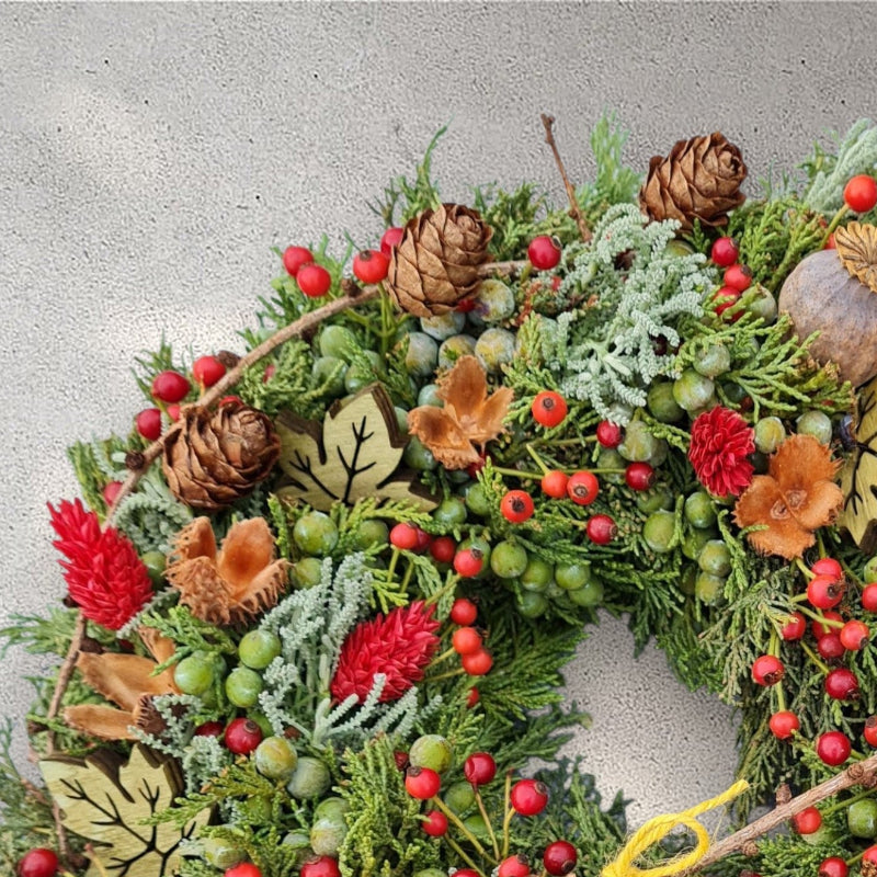 Detailaufnahme: Thujenkranz mit zarten Beeren, erinnert an den Duft und die Stille eines herbstlichen Waldes.