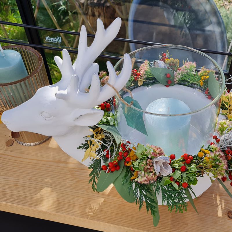 Der freche Hirsch aus weißem Polyresin und seinen kurzen Holzfüßchen trägt ein Windlicht mit Stumpenkerze. Geschmückt mit einem Trockenblumenkranz in den Farben der Saison bringt dieser durch seine kesse, bauchige Figur Schwung in die dunkle Jahreszeit. Modern und effektvoll ergänzt er die elegante Winter und Weihnachts-Dekoration.