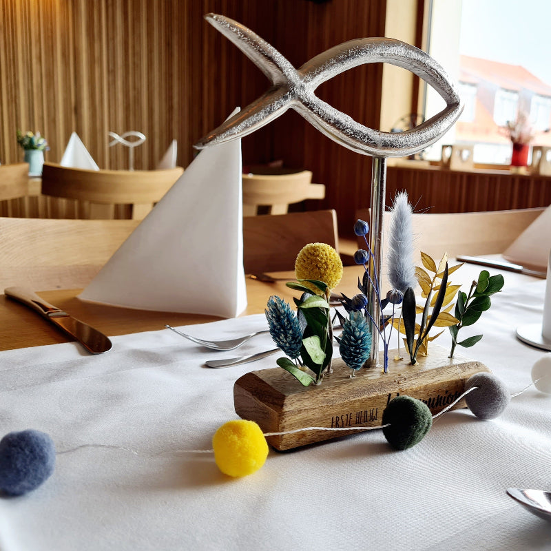 Ein personalisierter Fisch am Platz des Kommunionkindes steht auf einer festlich dekorierten Tafel. Eine ganz besondere Tischdeko zur Kommunion.