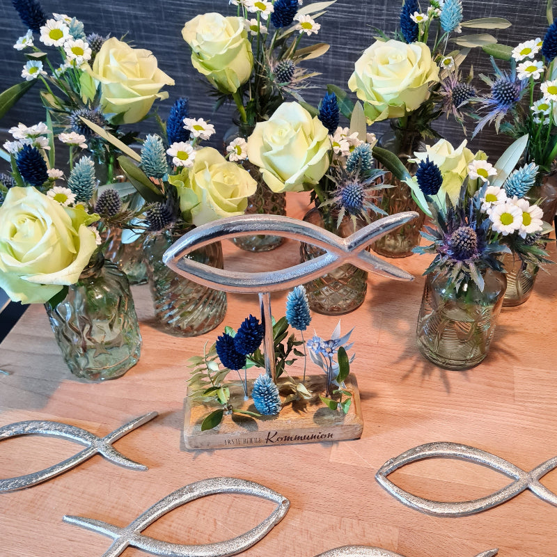 Gefüllte Glasvasen mit Farnen, Gräsern, Kamille und blauer Distel zur Feier einer Kommunion. Eine sehr stimmige Tischdekoration, auch geeignet für Konfirmation und Taufe.